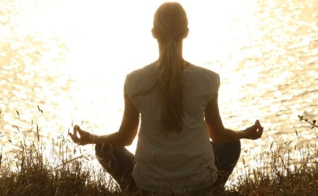 A woman meditating outdoors